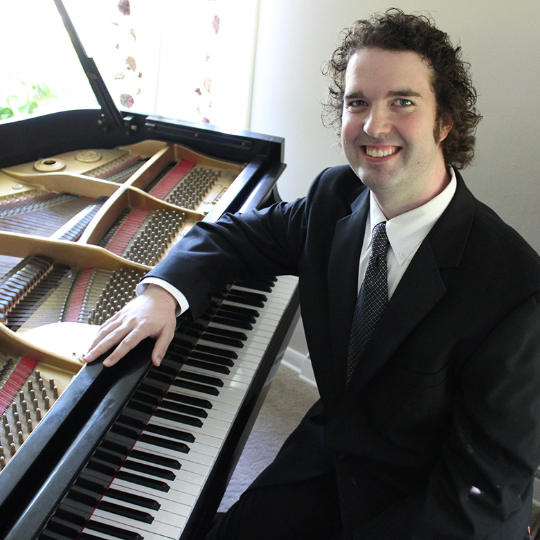 Peter Douglas smiling while sitting at a piano