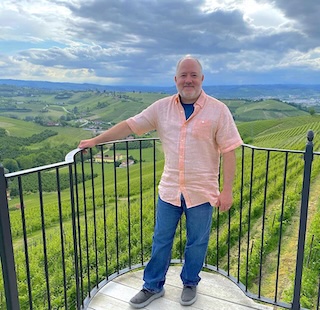 Dr. Erich Stem wearing a pink shirt and blue jeans at the Alba Music Festival in Alba, Italy.