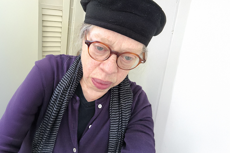 Lady with glasses in a dark blouse and beret