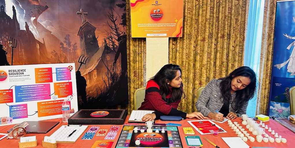 Nithika and Rithika Elugula demonstrate their board game Resilience Showdown
