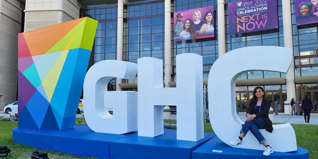 Student in front of Grace Hopper Conference sign