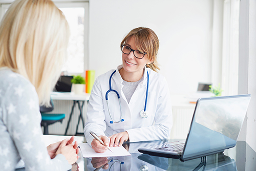 Shot of a middle aged female doctor sitting in front of laptop and consulting with her patient.