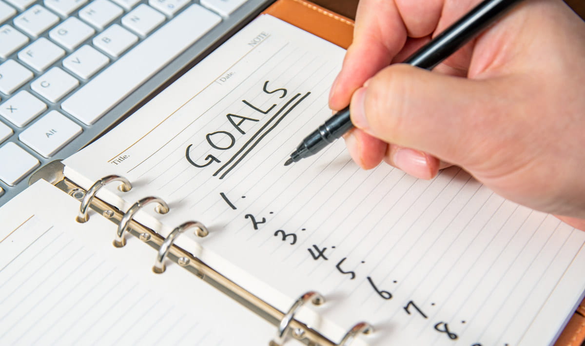 writing goals on a notepad