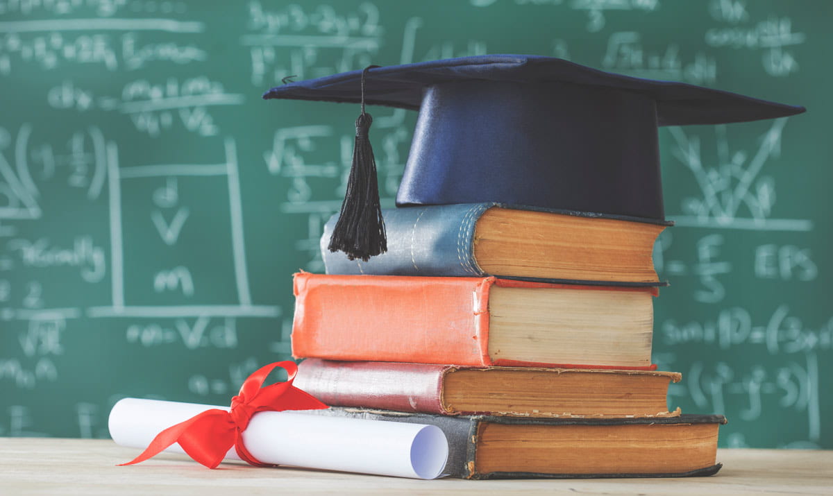 graduation cap on top of books