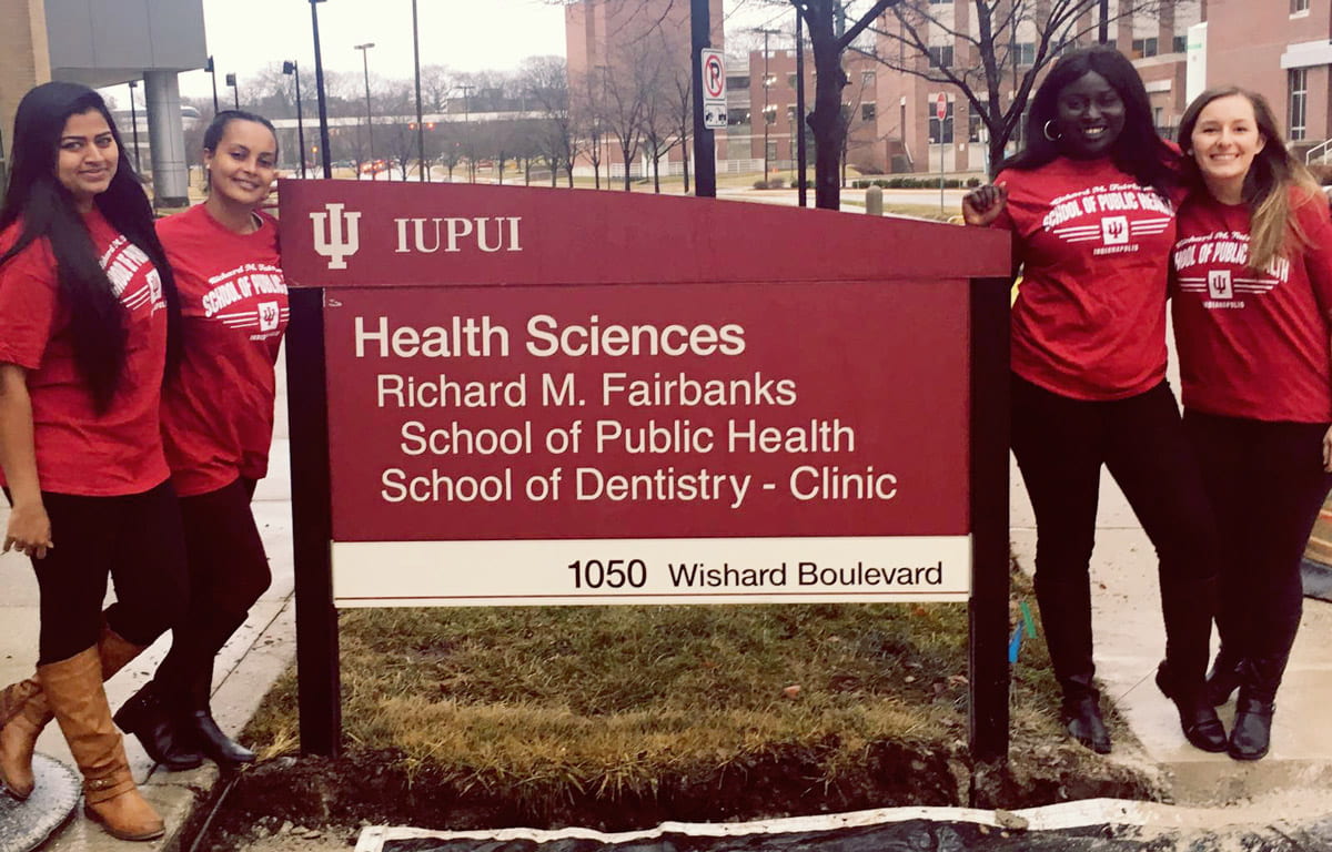 public health students posing with FSPH building sign