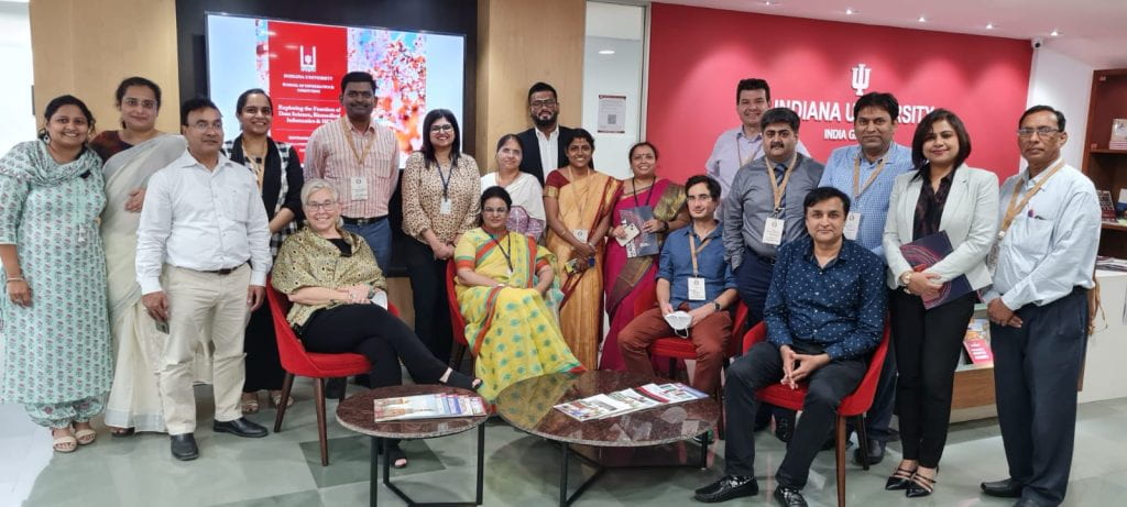 A group of people standing together and holding a red IU flag