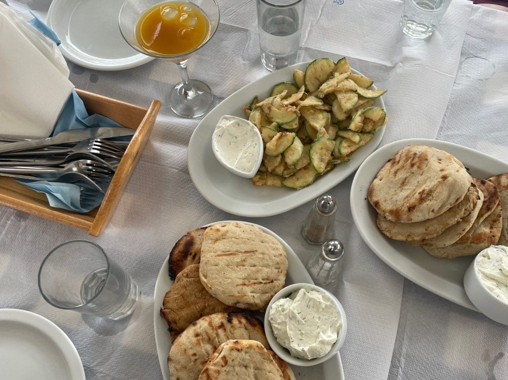 Pita bread and various dips displayed on a white tablecloth