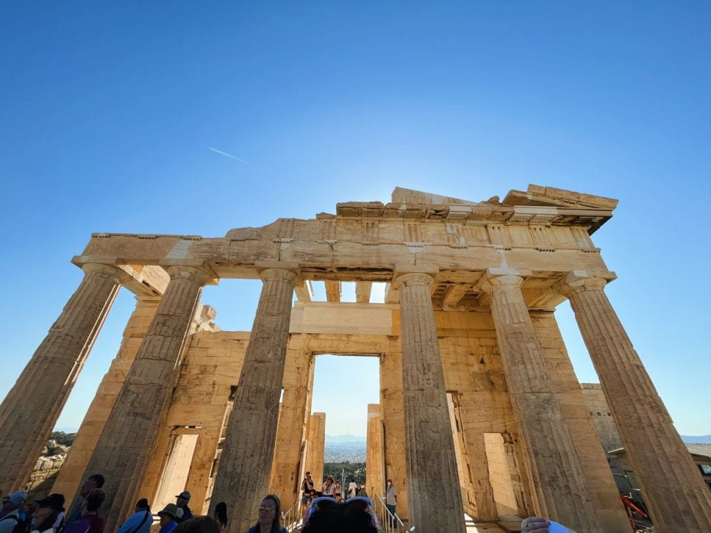 Low angled view of ancient columns against a blue sky
