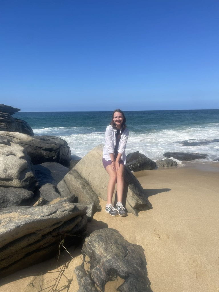 A woman stands on the beach on a sunny day