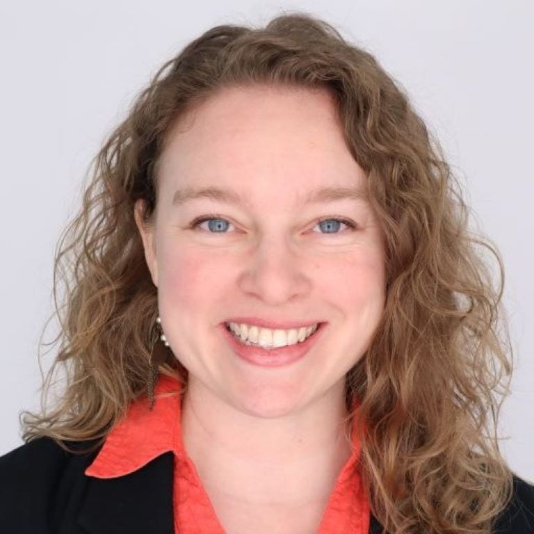 three people sit in front of a dry erase board