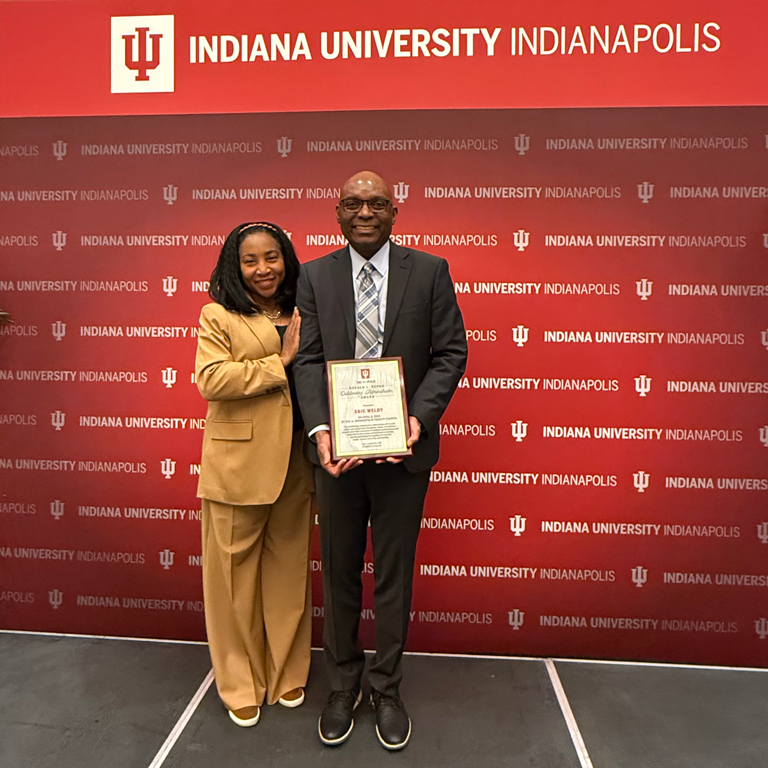 Dr. Weldy holding an award with his wife.