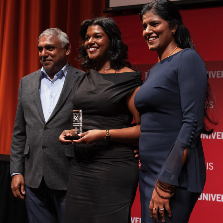 2025 Elite 50 honoree poses with family and award.