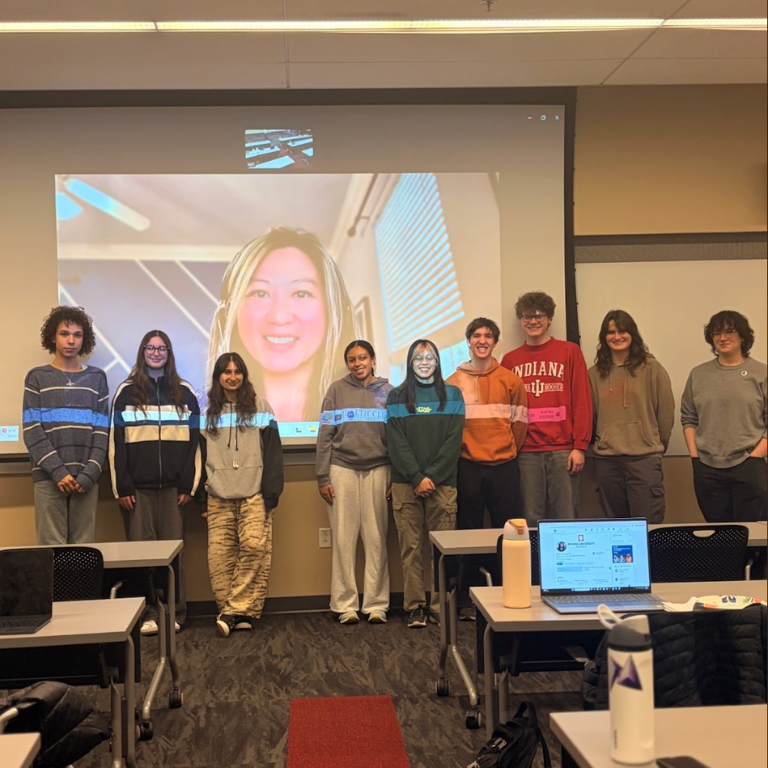 Club members pose for a picture with a guest speaker at a meeting.