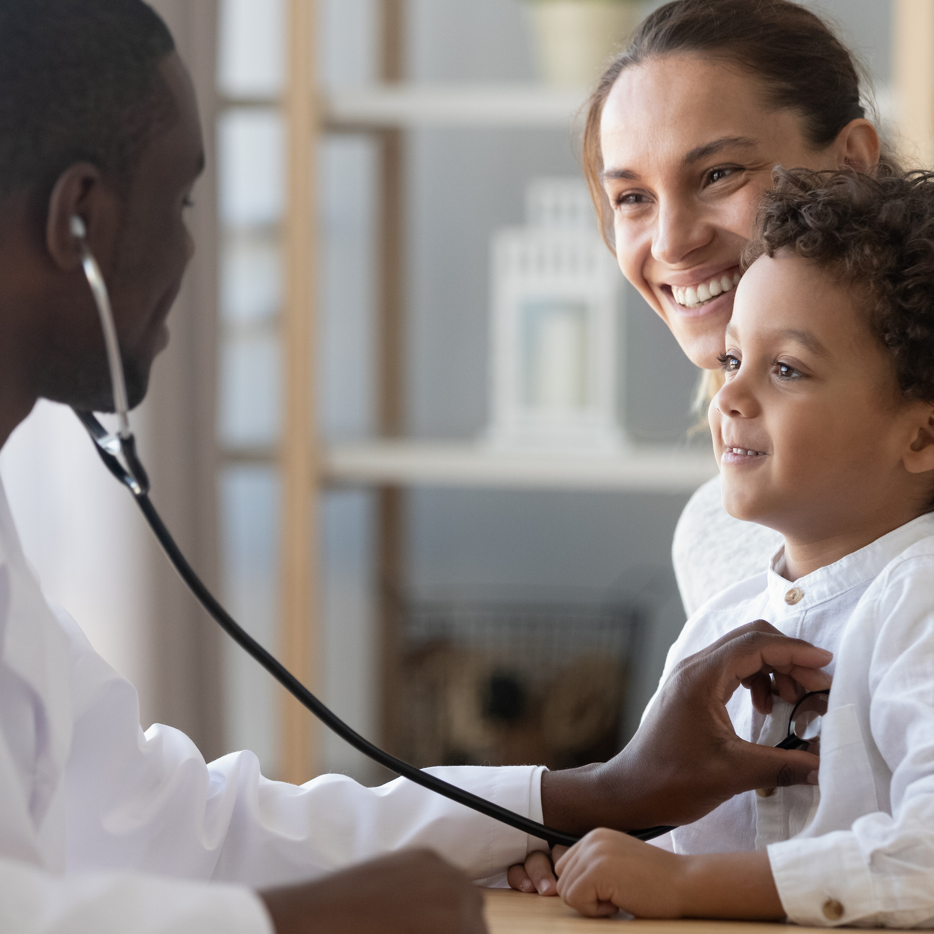 African male pediatrician hold stethoscope exam child boy patient visit doctor with mother, black paediatrician check heart lungs of kid ...